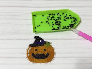 プレートにビーズを並べてハロウィンかぼちゃの形を作っている途中の様子